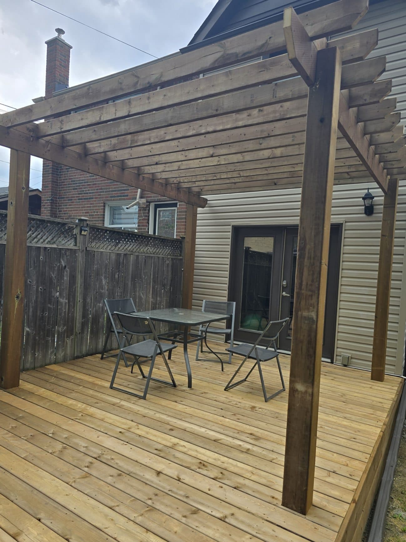 New pressure-treated deck with a stained pergola over the dining area